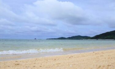 曇り空の下に広がる沖縄のビーチ。晴天のイメージとは異なるリアルな空模様